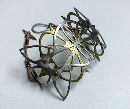 metal cuff of overlapping brass and silver designs