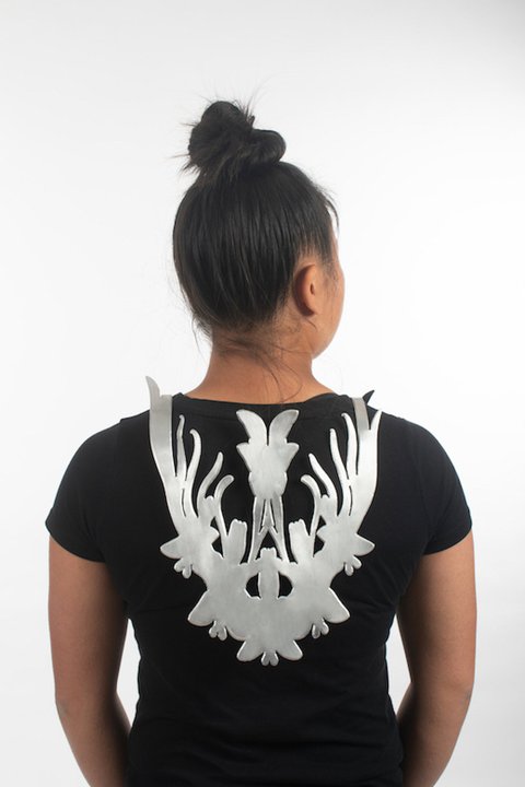 Girl wearing silver necklace of butterfly cutouts