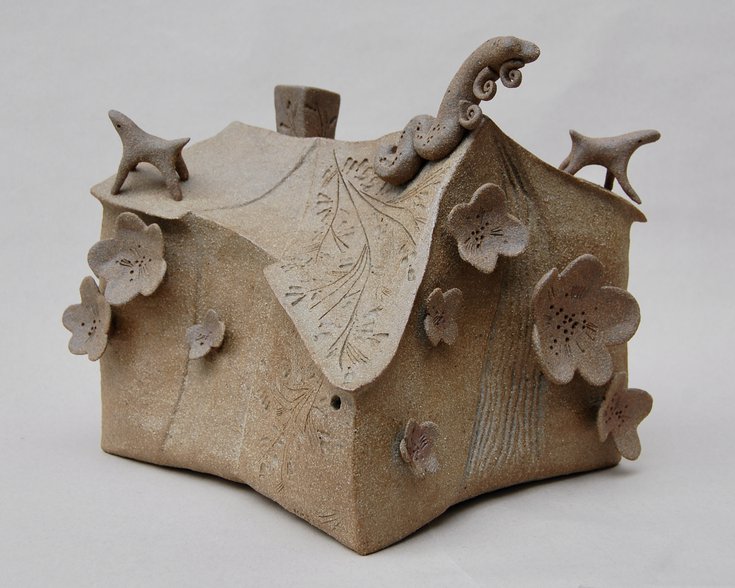 Ceramic brown house with flowers and animals added