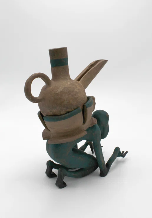 crouched green figure with vessel on back