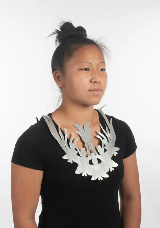 Girl wearing silver necklace of butterfly cutouts