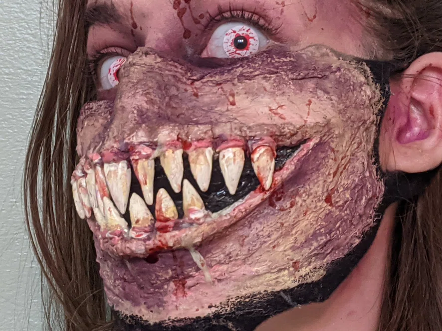 Girl wearing mask with prosthetic teeth
