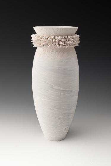 White wheel thrown ceramic vessel with opening sur